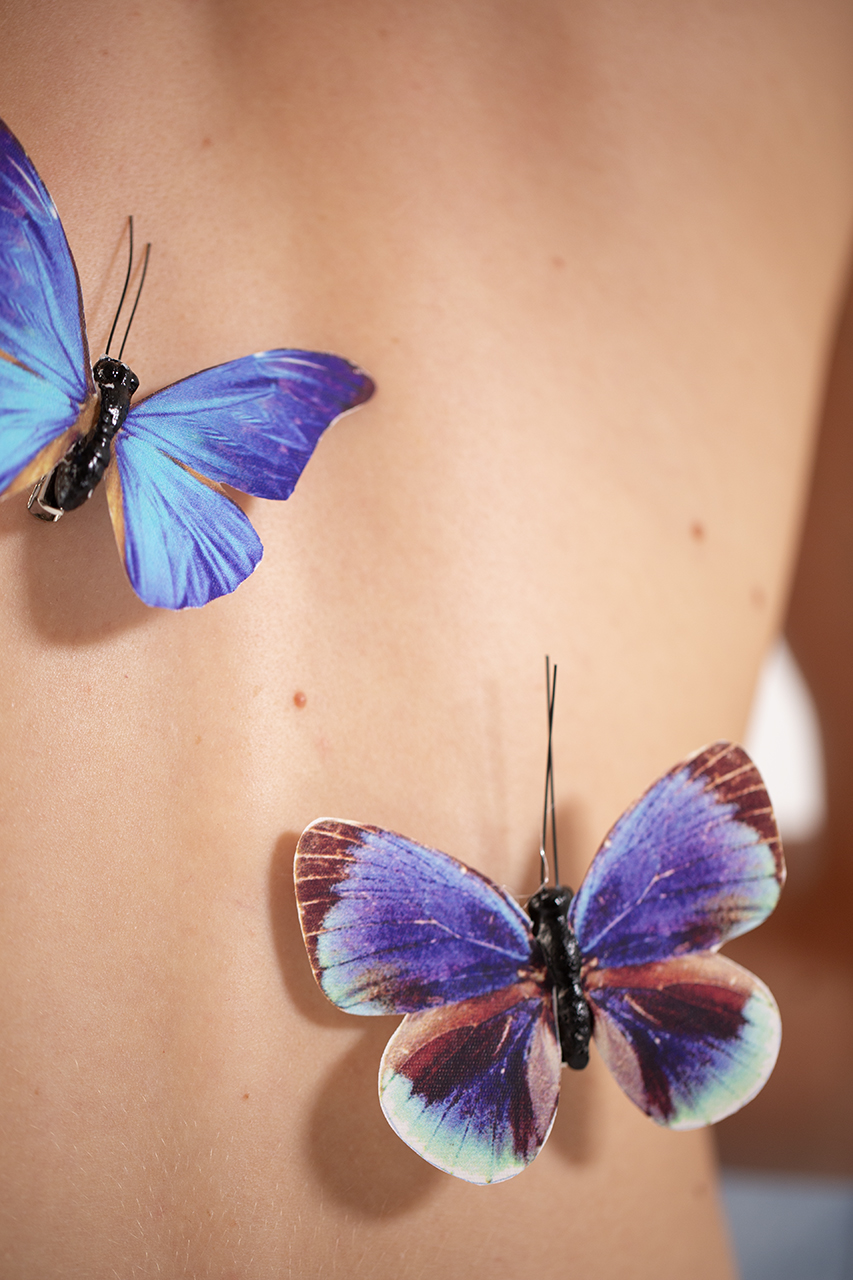 Le farfalle si appoggiano sulla schiena della modella